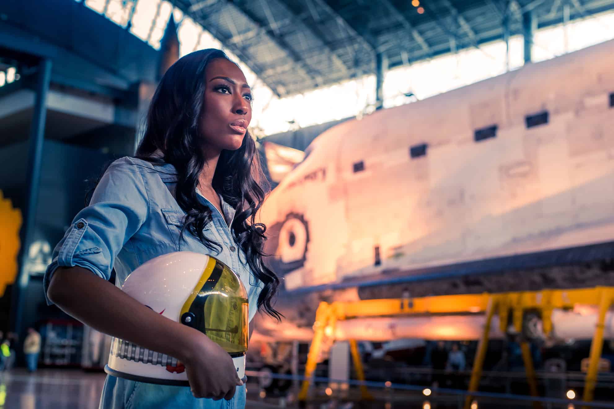 Photo of Aisha Bowe carrying her space helmet.